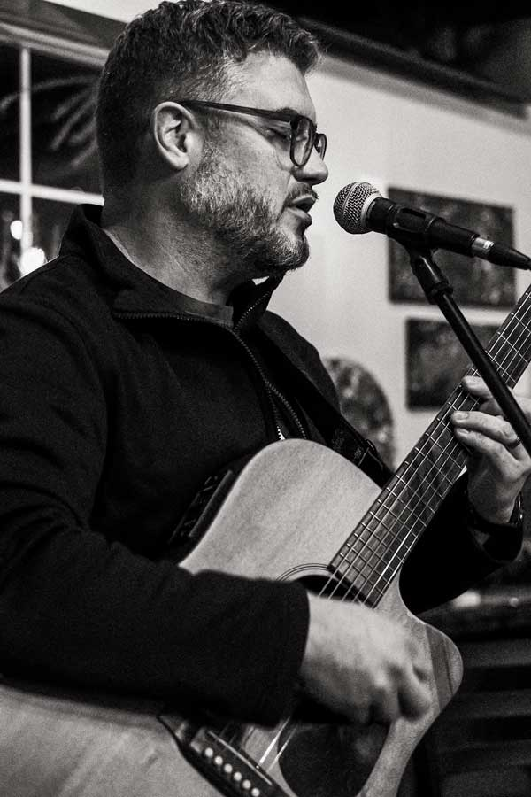 Guitar player Mike Schell playing a local gig at 8th Day Brewing.