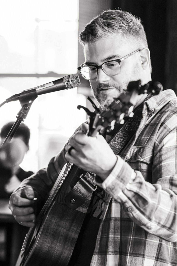 Mike Schell playing acoustic guitar